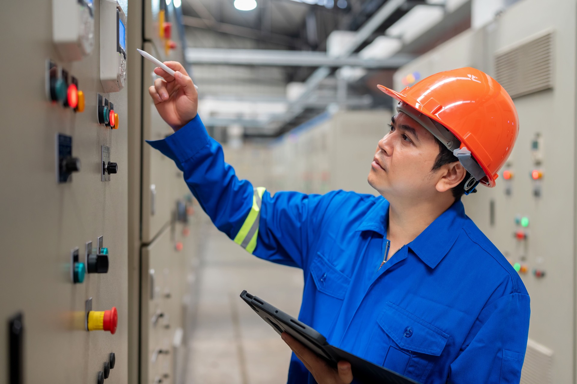 Power Engineer Utilizing Tablet for Real-Time Data in Control Room. Digital technology in maintaining and improving power systems.